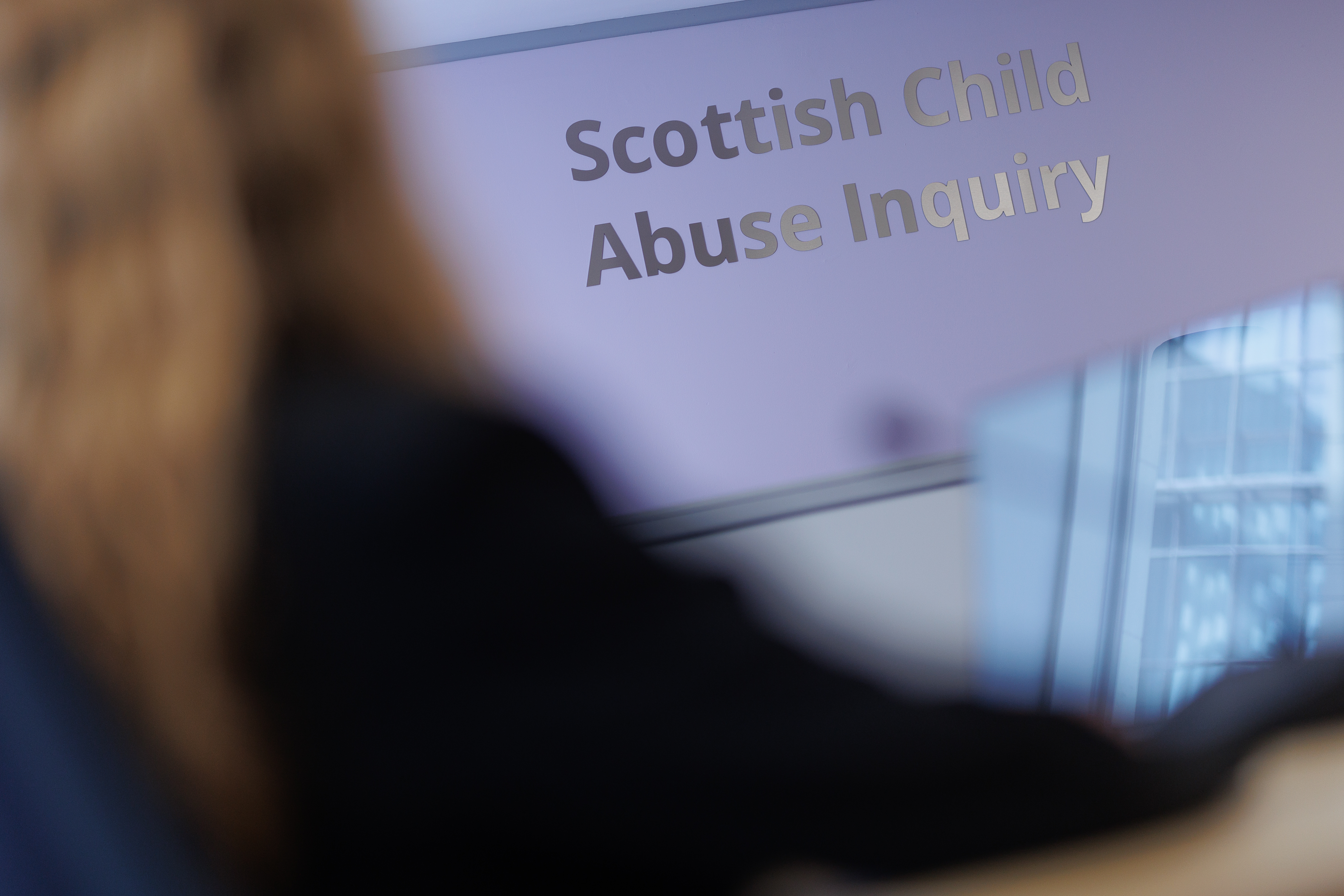 Picture of sign saying Scottish Child Abuse Inquiry on a lilac wall